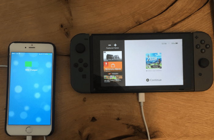 A smartphone charging Nintendo Switch