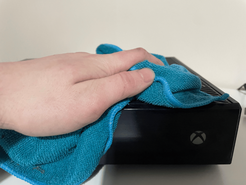 Wiping Xbox One exterior with micro fibre cloth